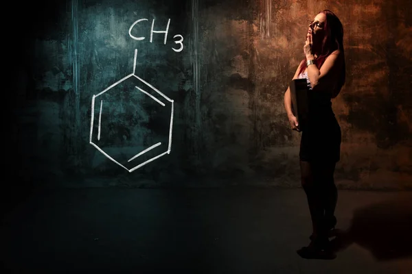 Σέξι κορίτσι ή γραμματέας ή μαθήτρια που παρουσιάζει χημική φόρμουλα τολουλίου — Φωτογραφία Αρχείου