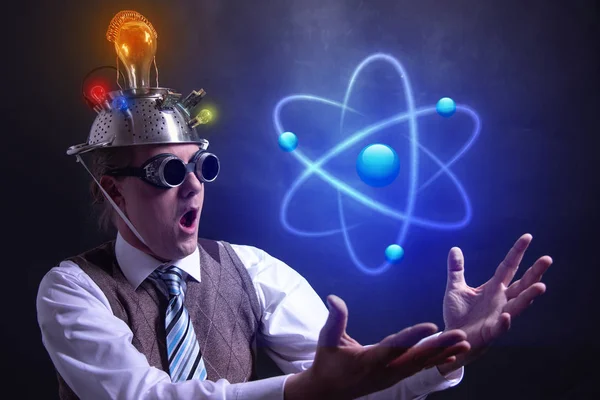 Nerd con cappello in stagnola che presenta l'icona Atomo — Foto Stock