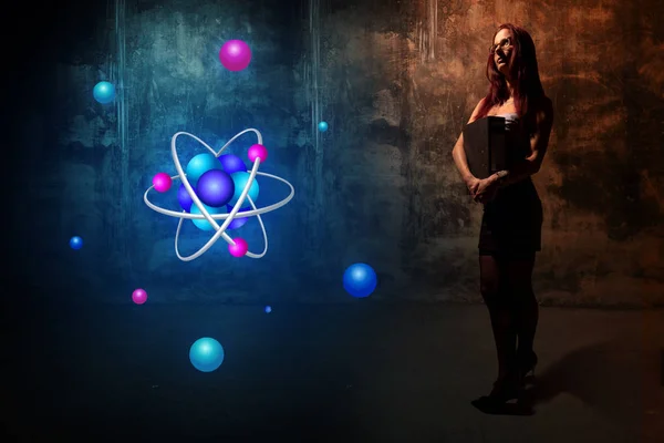 Сексуальний молодий секретар студент або вчитель, що представляє значок атома — стокове фото