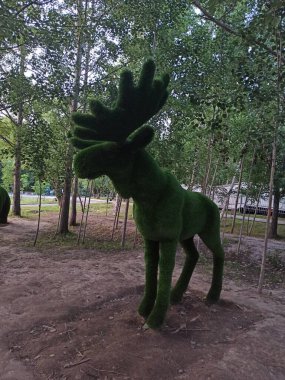 Park, büyük bir geyiğin heykeli.
