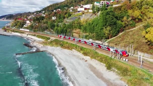 Sochi, Ryssland. Elektriska tåg sväljer Rider längs Svarta havets kust. Flygfotografering. — Stockvideo