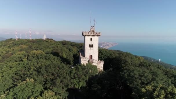 De quadrocopter vliegen naar de toren van Akhun. Groene bossen, blauwe hemel. Toeristische attractie van Sotsji. Luchtfoto enquête. — Stockvideo