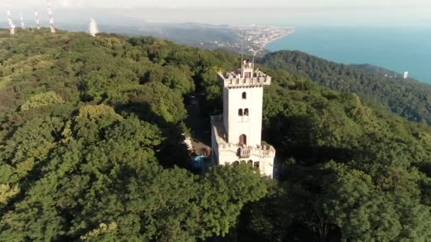 De quadrocopter vliegen naar de toren van Akhun. Groene bossen, blauwe hemel. Toeristische attractie van Sotsji. Luchtfoto enquête. — Stockvideo