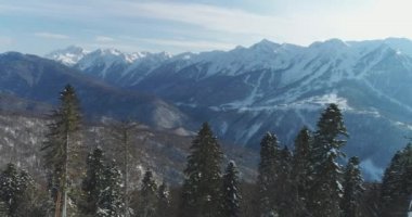 Karla kaplı ağaçlar ve dağlar içinde geçmiş. Sochi, Krasnaya Polyana, Rosa Khutor, helikopter ile hava fotoğrafçılığı. Dağlarda dinlenmek, doğada tatil. Kış sporları. Caucasus.