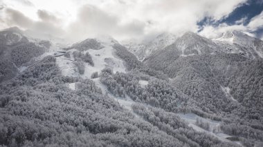 Dağlarda kar Panoraması. Dağlar üzerinde gri gökyüzü. Tatil Soçi, dağlarda dinlenmek. Kayak, snowboard, freeride. Helikopter ile hava fotoğrafçılığı. Dağ yolu