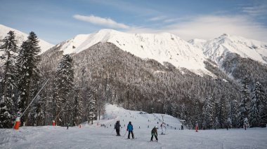 Rüzgârla oluşan kar yığını snowboard ile oturan ve kar savurma eğleniyor kayakçı mutlu Grup