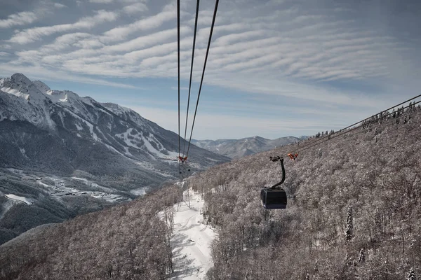 Flight of the camera over mountains. Aibga Ridge. Cable car with cabins go through the clouds. Mountains near the ski resort of Rosa Khutor in Krasnaya Polyana. Sochi.