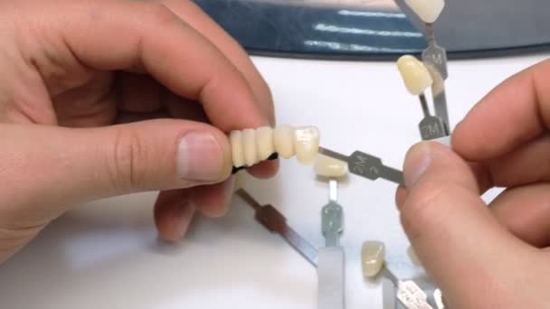 牙医手磨房牙冠 牙科技师在口腔实验室中使用陶瓷牙冠 — 图库视频影像