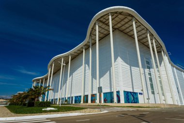 Soçi, Rusya - 13 Okt, 2016: Ana Olimpiyat Media Center'ın yeni modern bina Rus Uluslararası Yatırım Forumu için bir mekan olarak kullanılır. Giriş görünümü ile açık mavi gökyüzü yaz
