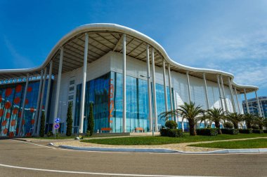Soçi, Rusya - 13 Okt, 2016: Ana Olimpiyat Media Center'ın yeni modern bina Rus Uluslararası Yatırım Forumu için bir mekan olarak kullanılır. Giriş görünümü ile açık mavi gökyüzü yaz