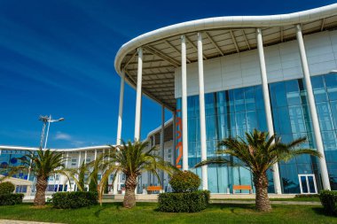 Soçi, Rusya - 13 Okt, 2016: Ana Olimpiyat Media Center'ın yeni modern bina Rus Uluslararası Yatırım Forumu için bir mekan olarak kullanılır. Giriş görünümü ile açık mavi gökyüzü yaz