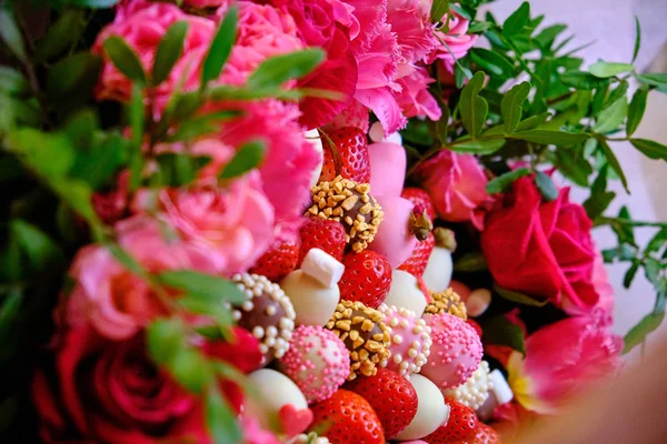 A delicious bouquet of strawberries and roses. close-up on the t