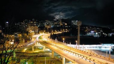 Yol Kavşağı'nda Sochi Timelapse. Şehir trafiği. akşam aydınlatma yolun. Meşgul karayolu üzerinde araçların hareketi. Şehir gece hayatı.