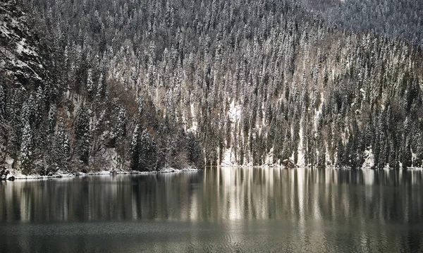 Linda montanha Lago Ritsa. Lago Ritsa, nas montanhas do Cáucaso, na parte noroeste da Abcásia, Geórgia, rodeado por florestas de montanha mistas e prados subalpinos. Neve nas montanhas — Fotografia de Stock