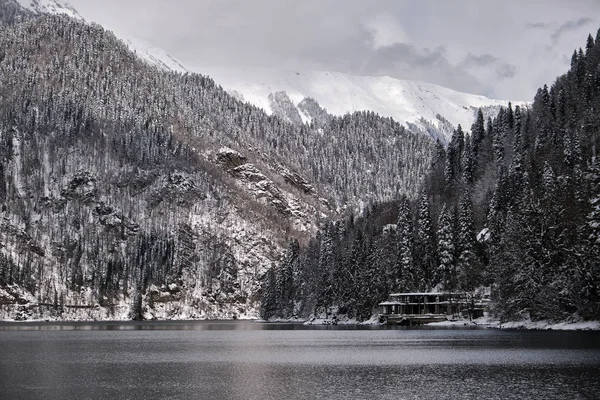 Hermosa montaña Lago Ritsa. Lago Ritsa en las montañas del Cáucaso, en la parte noroeste de Abjasia, Georgia, rodeado de bosques mixtos de montaña y prados subalpinos. Nieve en las montañas —  Fotos de Stock
