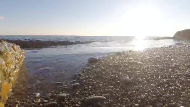 タイムラプス水の太陽の反射波と海に沈む夕陽 岩の多いビーチ クローズ アップ — ストック動画