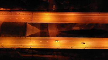 Hangi otomobil, otobüs, Uav.The yolda hava ateş kamyon gidin. Akşam aydınlatma parça. Yan yol Otoban tıkanıklık şehir merkezini kaydeder. Parça ile paralel hareket. Sarı sokak ışık