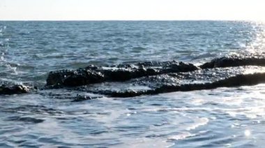 Deniz dalgalarının yavaş hareketi. Mavi gökyüzü ve su. Yaz günü. Denizin yanında dinlen. Soçi Doğa. Karadeniz. Yakın çekim.