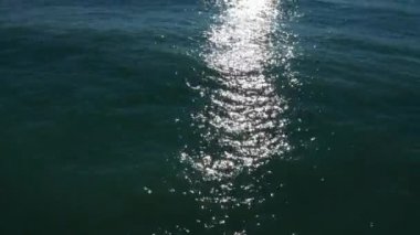 Bir quadcopter'dan havadan ateş. Kamera denizin üzerinde uçuyor. Deniz yüzeyi. Sonsuz ufuk. Güneşli bir gün. Panorama çekimi. Güneş suda parlıyor. Filmin başlangıcı. Sahil, ufukta kara