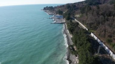 Hava aracı. Kıyı şeridinde uçuyor. Bir bahar gününde mavi gökyüzünü temizler. Soçi Karadeniz sahili. Kıyı şeridi. Mavi deniz suyu. Panorama çekimi