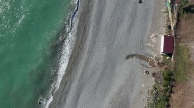 Hava aracı. Kıyı şeridinde uçuyor. Bir bahar gününde mavi gökyüzünü temizler. Soçi Karadeniz sahili. Kıyı şeridi. Mavi deniz suyu. Panorama çekimi