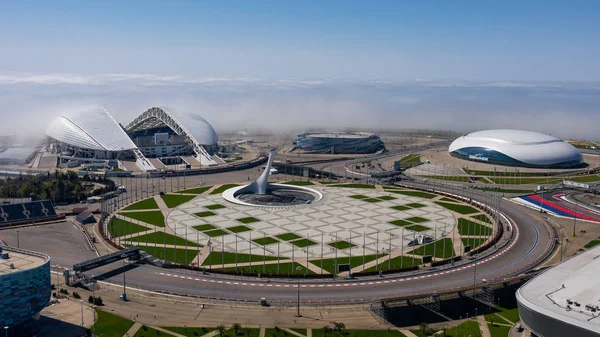 Sochi, Rússia- 27 ABR 2019 De manhã cedo sobre o Parque Olímpico Sochi caiu nevoeiro pesado do mar Negro. Fotografia aérea com quadrocopter.O estádio Fisht, a chama olímpica nas nuvens . — Fotografia de Stock