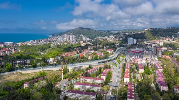 Aerial photography. Urban infrastructure. Dense building. Residential building. Sea view from the window. Coastal town. High-rise buildings on the mountain. The black sea coast of Sochi, Russia.