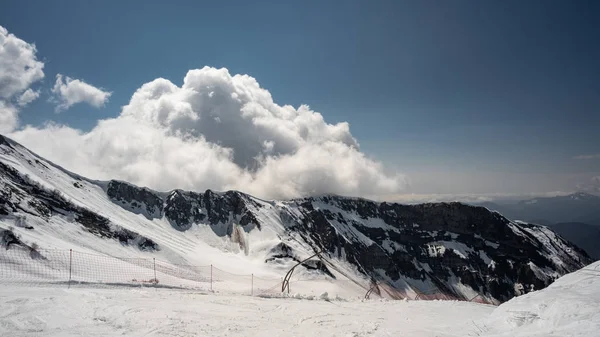 航空写真。雪に覆われた山々。青空に雲。ソチのアイブガ山頂。スキー リゾート クラスナヤ ポリアナ. — ストック写真