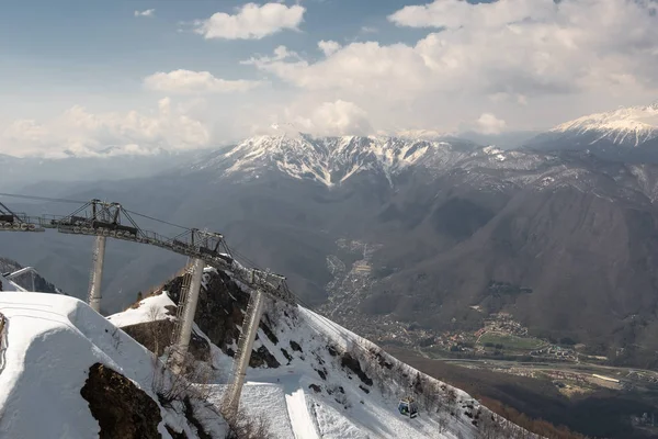 Fotografia aérea. Teleférico para o topo da montanha coberta de neve Aibga. Estância de esqui Krasnaya Polyana, Sochi. Férias nas montanhas. A vista de cima . — Fotografia de Stock