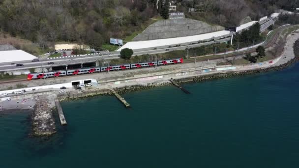 航空写真撮影 ソチのリゾート地の観光客や住民は 晴れた春の日に黒い海の海岸に沿って高速列車ツバメに行きます 都市間の輸送ルート — ストック動画