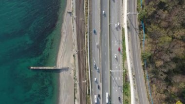 Havadan video çekimi. Soçi'nin Karadeniz kıyısı. Sahil boyunca yol. Ufukta gün batımı. Panorama çekimi.