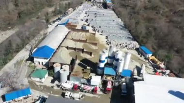 Havadan video çekimi, beton ve asfalt üretimi. Sanayi dükkanı. Yukarıdan manzara. Hiperlapse modunda çekim. Hızlı hareket. Kamyon. Beton mikseri. Kum ve çakıl taban depolama.