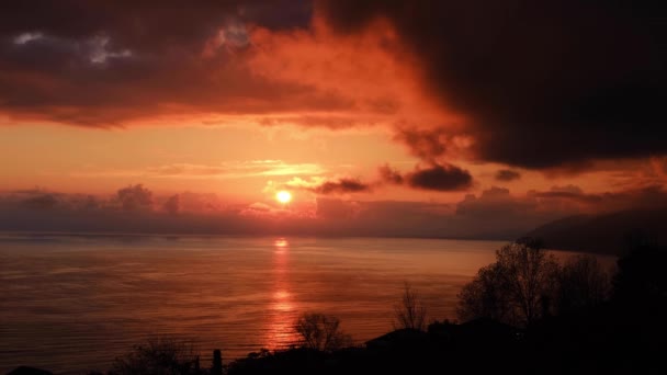 海に赤い夕日 太陽が地平線の上に沈んでいる 山と海の夕景 空に大きな積雲 上からの美しい眺め — ストック動画