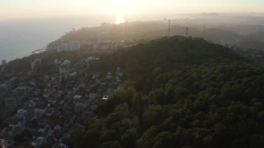 Havadan video çekimi. Akşam şehrinin üzerinden uç. Günbatımı. Soçi, Rusya'nın Karadeniz kıyıları. Ufkun panoramik manzarası. Kimse yok. Gökyüzünü temizle. Sarı ışık.
