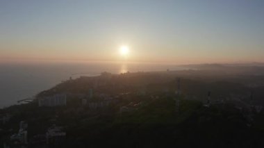 Havadan video çekimi. Akşam şehrinin üzerinden uç. Günbatımı. Soçi, Rusya'nın Karadeniz kıyıları. Ufkun panoramik manzarası. Kimse yok. Gökyüzünü temizle. Sarı ışık.