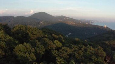 Havadan video çekimi. Soçi şehrinde gün batımı. Akşam ışığı. Şehrin üzerinde pus. Yerleşim alanı. Karadeniz kıyıları. Panorama çekimi. Yukarıdan manzara. Sarı ışık