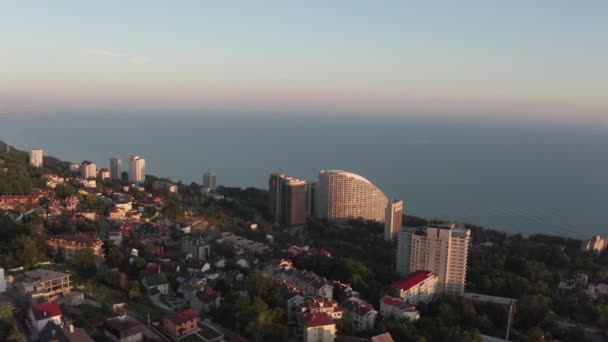 航空写真撮影 ロシア ソチのリゾート地にある黒海沿岸のパノラマショット ビーチの住宅とホテル 夕方の眺め — ストック動画