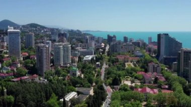 Havadan video çekimi. Karadeniz'de tatil kasabası. Soçi, Rusya. En yüksek bina. Lüks oteller. Şehir merkezi. Mavi gökyüzünü temizle. Yukarıdan panoramik görünüm.