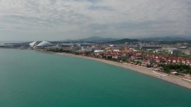 Havadan video çekimi. Şehir tatil köyü. Sahil alanı. Turistler için rekreasyon alanı. Soçi'nin Karadeniz kıyılarının panoramik manzarası. Tatil sezonu. Dinlenme süresi.