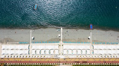 Hava fotoğrafçılığı. Yukarıdan plaj manzarası. Rekreasyon alanı ve denizde yüzme. Temiz deniz suyu. Tatil sezonu.