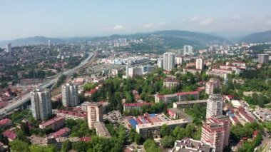 Havadan video çekimi. Karadeniz kıyısındaki büyük şehir. Metropolün merkezi. Uzun bir ev. Sochi, Rusya şehir merkezi. Tren istasyonunda. Liman. Merkez cadde. Yerleşim alanı.