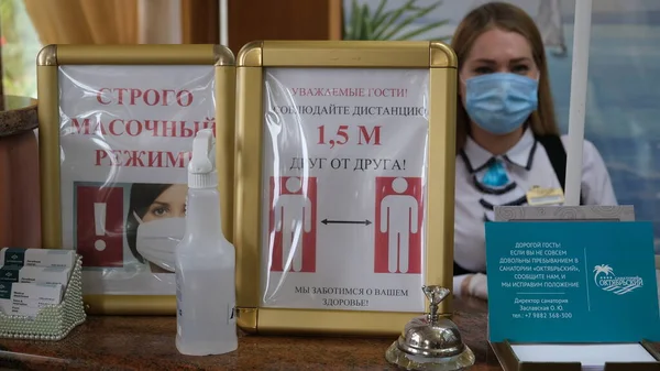 Sochi, Rusya - 06.01.2020 Koruyucu tıbbi maske takan bir kız. Resepsiyon. Otelde. Tamamen maskeli mod. Birbirinizden uzak durun. Sağlığınıza önem veriyoruz.. 