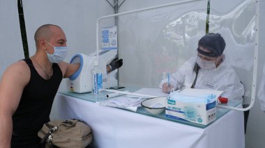 Sochi, Rusya - 01.06.2020 Doktor kontrolü. Covid 19. Coronavirus. Salgın. Bir tıp uzmanı. Yalıtım. Vay be. Testleri topluyorum. Vücut sıcaklığını kontrol et.