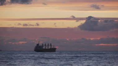 Denizdeki nakliye gemisi. Güzel turuncu gün batımı. İyi akşamlar. Deniz yoluyla nakliye. Konteyner gemisi. 