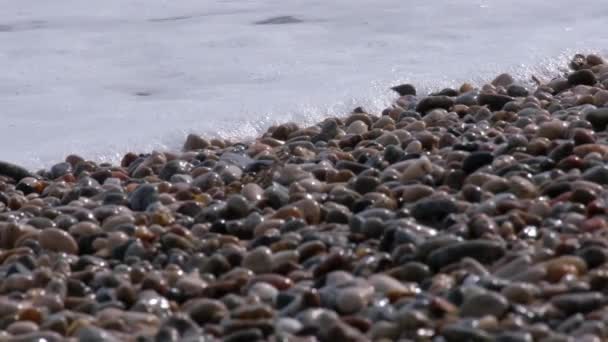 Wellen am Meeresufer. Steine am Strand. Kieselstrand. Welle. Ufer. Zeitlupe. Kein Volk. Gezeiten. — Stockvideo