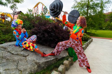 Sochi, Rusya - Haziran 07, 2020 Palyaçolar sokaktaki kameraya poz verdiler. Kostümlü oyuncular. Tatil günü. Maskeli balo. Makyaj. Peruk. Takım elbise. Sochi Parkı. 