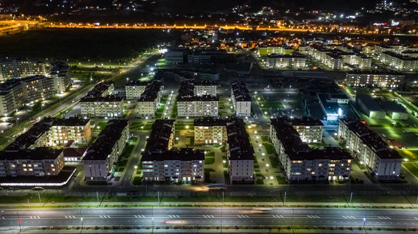 Night city. Evening lighting of the building. Residential area of the city. Sochi Olympic Park. Sunset. Multi-storey building.