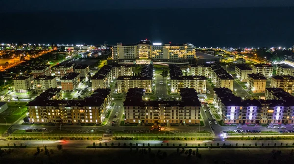 Night city. Evening lighting of the building. Residential area of the city. Sochi Olympic Park. Sunset. Multi-storey building.