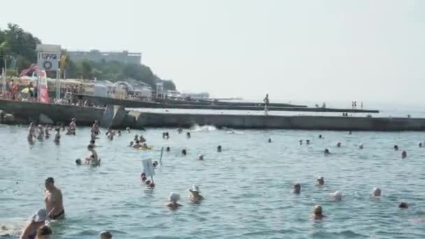 Sochi, Rússia - 20 de julho de 2020: Um grupo de pessoas de sochi na praia. Turistas tomar banho e se divertir no resort de luxo. Conceito de recreação e entretenimento . — Vídeo de Stock