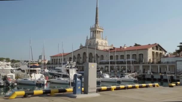 Sochi, Rusland - 20 JULI 2020: De zeehaven van Sochi. Schepen en jachten liggen voor de kust. Historisch gebouw. Aantrekkingskracht. Het is een zonnige dag. — Stockvideo